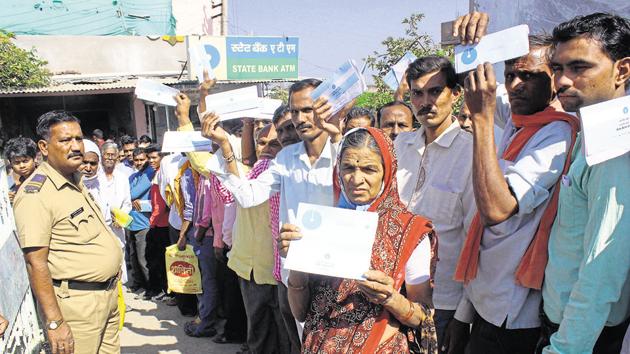 Kalavati Bandhurkar along with villagers queues before an SBI branch to withdraw cash in Maregaon village of Yawatmal district on Friday.(Sunny Shende / HT Photo)