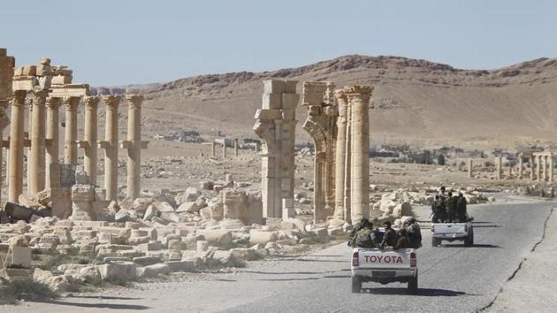 Syrian army soldiers drive past the Arch of Triumph in the historic city of Palmyra, in Homs Governorate, Syria in this April 1, 2016 file photo.(Reuters)