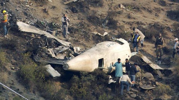 Pakistani investigators examine the wreckage of a passenger plane which crashed in the village of Gugh. (AP file photo) Pakistani investigators examine the wreckage of a passenger plane which crashed in the village of Gugh. (AP file photo)