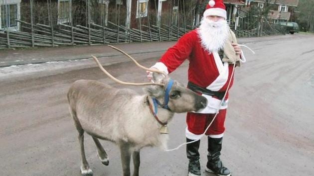 A man dressed as Santa Claus walks his pet reindeer as he visits hotels and shops in Sweden. (Reuters file photo) A man dressed as Santa Claus walks his pet reindeer as he visits hotels and shops in Sweden. (Reuters file photo)