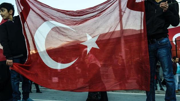 Youth hold a Turkish flag during a gathering outside the Vodafone Arena football stadium in Istanbul on December 11, 2016, a day after twin bombings near the home stadium of Besiktas football club. (AFP Photo) Youth hold a Turkish flag during a gathering outside the Vodafone Arena football stadium in Istanbul on December 11, 2016, a day after twin bombings near the home stadium of Besiktas football club. (AFP Photo)