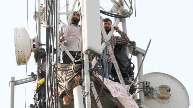 Deepak Kumar and Rakesh Kumar atop a mobile tower that they climbed on November 3, in Chandigarh. Rakesh has now come down.(HT File Photo)