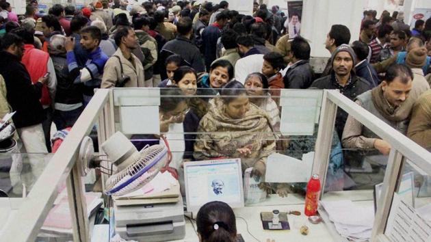 People stand in long queues to deposit and withdraw cash at a bank in Allahabad on Tuesday.(PTI photo)