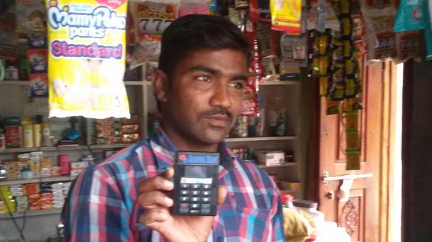 A provisions store owner in Ibrahimpur displays a Point of Sale machine for selling goods using smart cards.(HT photo) A provisions store owner in Ibrahimpur displays a Point of Sale machine for selling goods using smart cards.(HT photo)