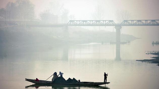 Kashmiri boatmen extract sand from the river Jhelum at Sangam south of Srinagar on December 8, 2016. (AFP)