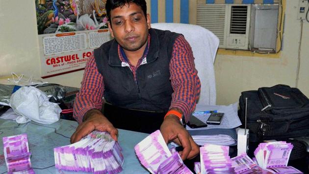 Police showing Rs 27 lakh in new currency notes recovered from four accused in Faridabad on December 13. (PTI Photo) Police showing Rs 27 lakh in new currency notes recovered from four accused in Faridabad on December 13. (PTI Photo)