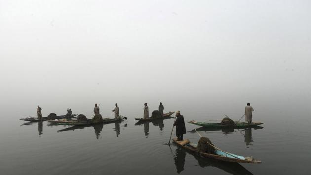Members of Kashmir's Lakes and Waterways Authority collect weeds lying on the surface of Dal Lake on December 10, 2016. (Waseem Andrabi/HT Photo)