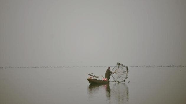 A fisherman casts his net from his boat during dense fog on Dal Lake in Srinagar on December 7, 2016. (AFP)