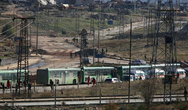 Buses and ambulances wait to evacuate civilians and rebels from eastern Aleppo.