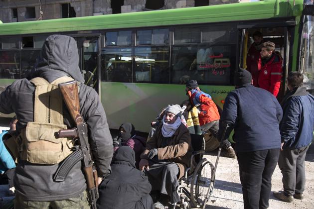 Syrians gather during the evacuation A convoy of ambulances and buses left rebel territory in Aleppo in the first evacuations under a deal for opposition fighters to leave the city after years of fighting. (AFP)