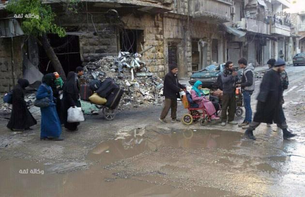 This image released by the Thiqa News Agency, shows civilians gathering for evacuation from eastern Aleppo. (AP)