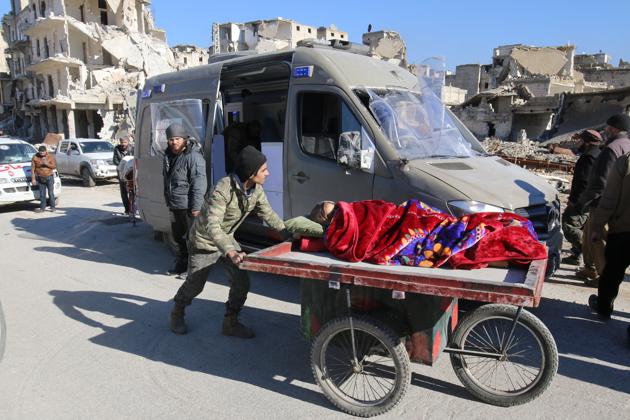 A man pushes a cart with a woman lying on it as vehicles wait to evacuate people from a rebel-held sector of eastern Aleppo. (REUTERS)