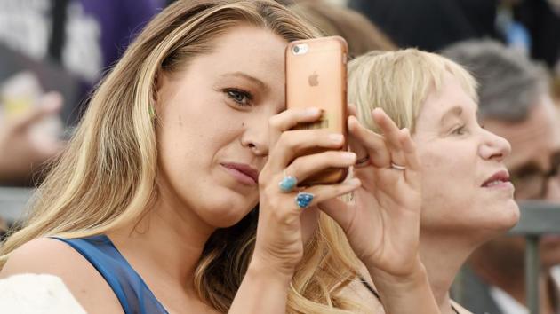 Actress Blake Lively points her iPhone at photographers during a ceremony. (Chris Pizzello/Invision/AP)