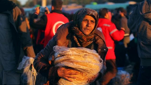 An evacuee from rebel-held east Aleppo carries bread upon her arrival with others at the town of al-Rashideen, which is held by insurgents, Syria. (Reuters Photo) An evacuee from rebel-held east Aleppo carries bread upon her arrival with others at the town of al-Rashideen, which is held by insurgents, Syria. (Reuters Photo)