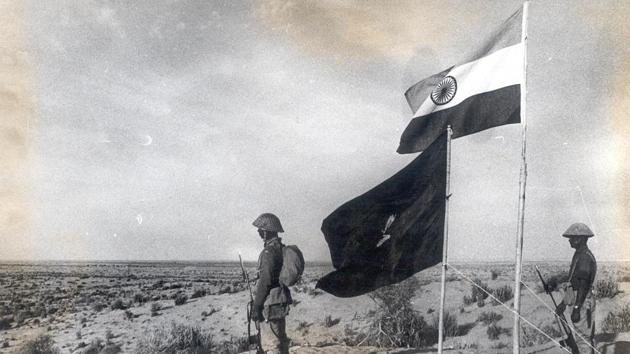 Indian soldiers stand next to the nation’s flag at an unknown location during the 1971 Indo-Pak war. (Photo division/defence wing)