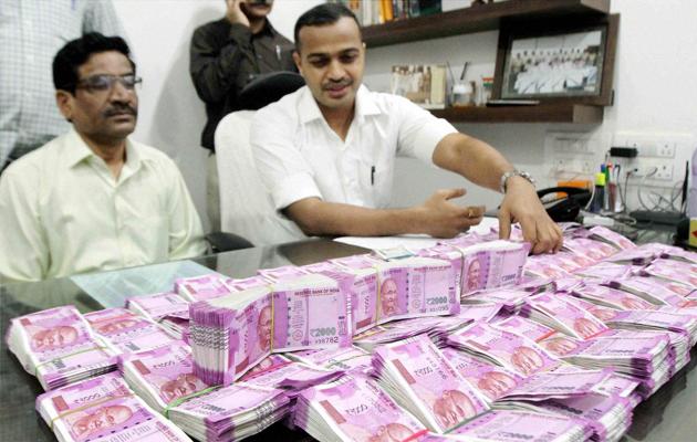 Crime branch police displays seized currency of rupees one crore and forty thousand in new notes in Thane on Wednesday.(PTI)
