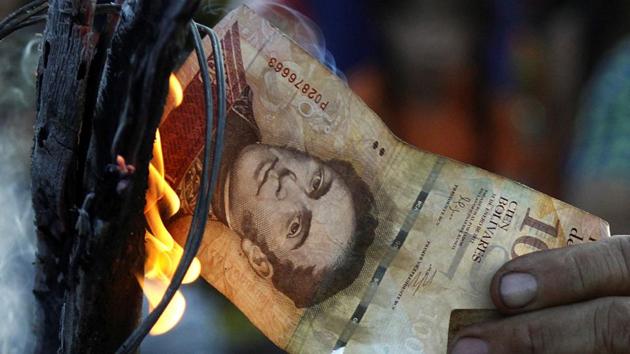 A man burns a 100-bolivar bill during a protest in El Pinal, Venezuela. (Reuters) A man burns a 100-bolivar bill during a protest in El Pinal, Venezuela. (Reuters)