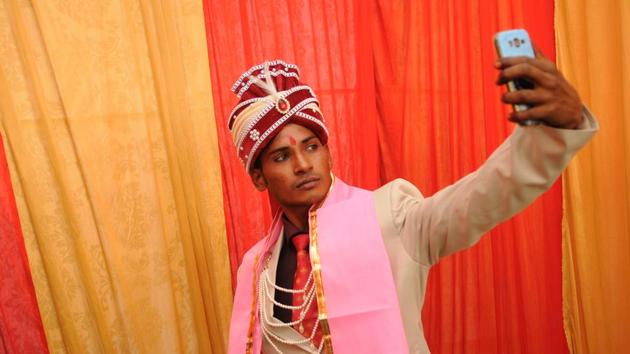 One of the grooms takes a selfie before the ceremony. There have been three such marriage events in the past in which more than 300 couples have tied the knot. (Burhaan Kinu/HT PHOTO) 