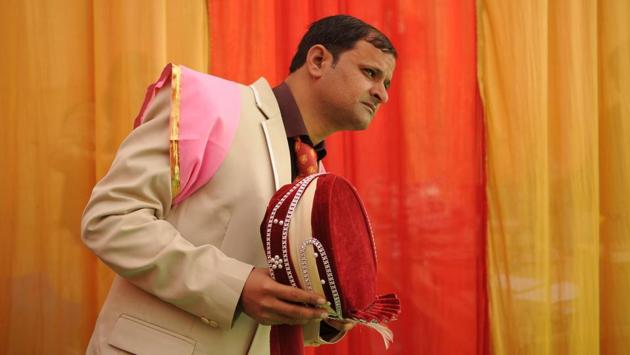One of the grooms waits by the side of the stage ahead of the ceremony. (Burhaan Kinu/HT PHOTO) 