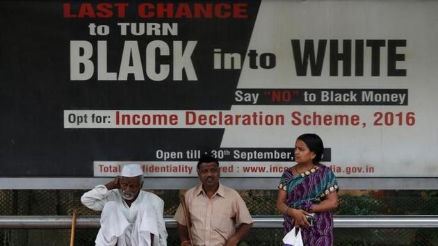 Passengers wait in front of an income tax billboard at a bus stop in New Delhi. (Reuters) Passengers wait in front of an income tax billboard at a bus stop in New Delhi. (Reuters)
