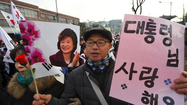 A Supporter of South Korea's President Park Geun-Hye holds banners showing a portrait of Park and reading "I love the president" on December 17. (AFP Photo) A Supporter of South Korea's President Park Geun-Hye holds banners showing a portrait of Park and reading "I love the president" on December 17. (AFP Photo)