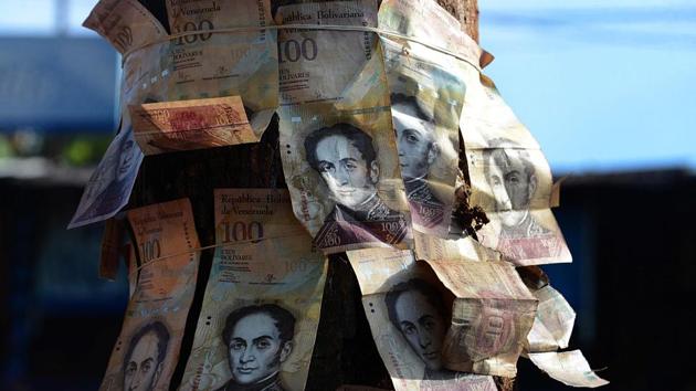 People tie 100-Bolivar notes to a tree during a protest over lack of cash as the new bank notes have not yet appeared, in Venezuela's Tachira state. (AFP Photo) People tie 100-Bolivar notes to a tree during a protest over lack of cash as the new bank notes have not yet appeared, in Venezuela's Tachira state. (AFP Photo)