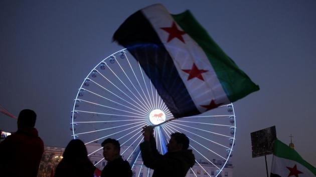 A man waves a Syrian flag during a gathering to protest against the war and the humanitarian crisis in Aleppo, in Lyon, central France. (Laurent Cipiani/AP Photo) 