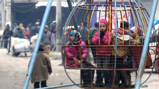 Children play while waiting to be evacuated with others from a rebel-held sector of eastern Aleppo, Syria.  (Abdalrehman Ismail/Reuters Photo) 
