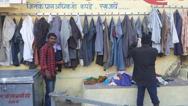 Two men check out garments left at the wall of kindness at Bhawanimandi in Jhalawar district on Sunday. (HT Photo) Two men check out garments left at the wall of kindness at Bhawanimandi in Jhalawar district on Sunday. (HT Photo)