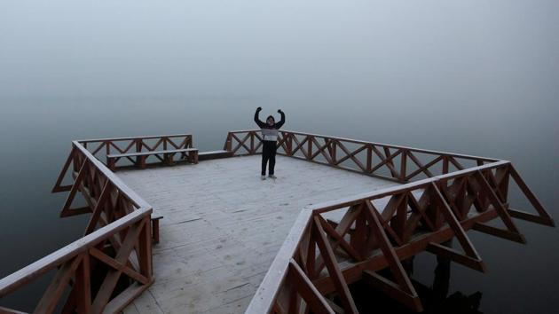 A man exercises on a jetty on the banks of Dal Lake on a cold winter morning in Srinagar. (Reuters Photo) A man exercises on a jetty on the banks of Dal Lake on a cold winter morning in Srinagar. (Reuters Photo)