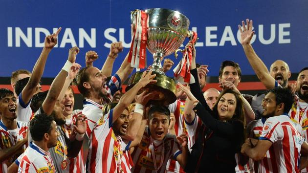 Atletico de Kolkata players celebrate with the trophy, presented by Indian Super League (ISL) director Nita Ambani (3rd R), after winning the ISL final football match against Kerala Blasters FC.(AFP)