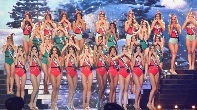Contestants gesture as they pose on stage during the swimsuit round in the competition.  (AFP) 