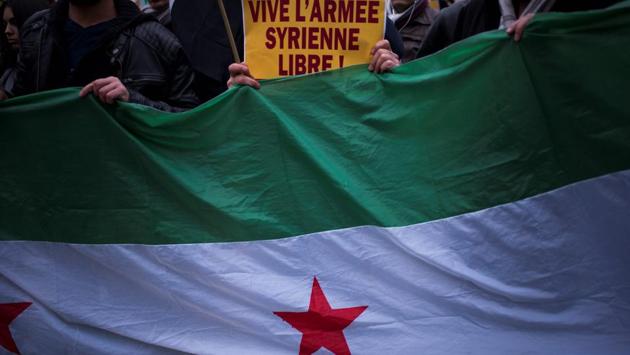 People hold a sign reading "long live Free Syrian Army" during a protest of Syrian demonstrators near the Iranian ambassy against Iranian involvement in the siege of Aleppo, in Paris. (Martin /AFP Photo) 