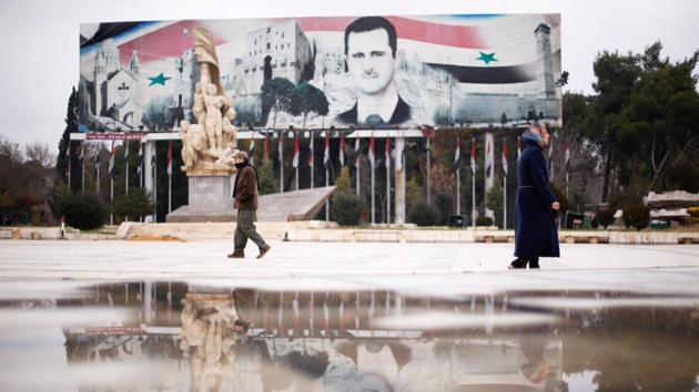 People walk past a billboard depicting Syria's President Bashar al-Assad at Saadallah al-Jabri Square, in the government controlled area of Aleppo, Syria. (Omar Sanadiki/Reuters Photo) 