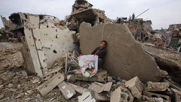 A Syrian boy sits with belongings he collected from the rubble of his house in Aleppo's Al-Arkoub neighbourhood after pro-government forces retook the area from rebel fighters.  (Youssef Karwashan/AFP Photo ) 