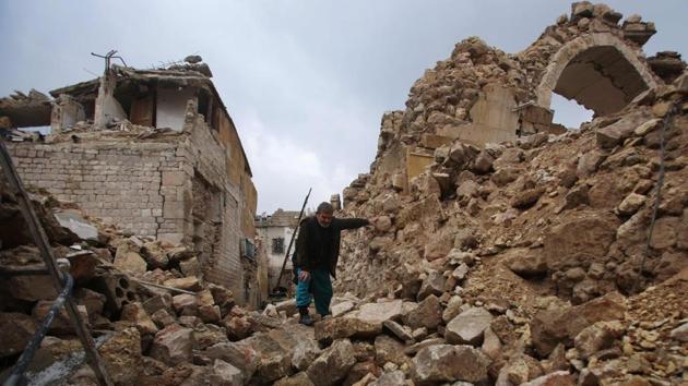 A Syrian man makes his way through the rubble of destroyed buildings as he heads to his house in Aleppo's Dahret Awad neighbourhood. (Youssef Karwashan/AFP Photo) 