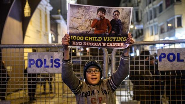 A Syrian boy living in Turkey holds a sign during a protest against Russia, Syrian president Bashar al-Assad's regime ally, in front of the Russian Embassy along Istiklal Avenue in Istanbul. (Ozan Kose/AFP Photo) 
