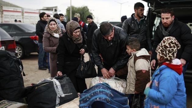 Syrian Ali, centre, last name not given, who currently resides in Turkey, talks to his son Zein, from Idlib, Syria, after he crossed into Turkey at the Cilvegozu border gate with Syria, near Hatay, southeastern Turkey. (Emrah Gurel/AP Photo) 