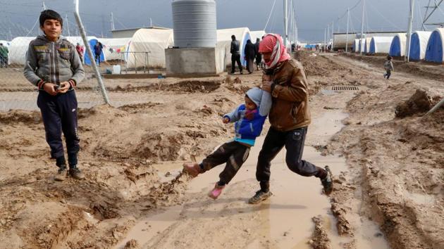 Displaced Iraqis who fled the Islamic State stronghold of Mosul, walk in the mud following heavy rain at Khazer camp, Iraq, December 19, 2016. (Ammar Awad / REUTERS)