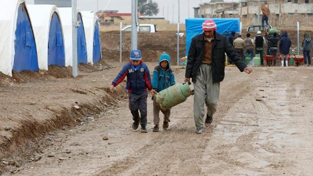 Displaced Iraqis who fled the Islamic State stronghold of Mosul, carry their belongings at Khazer camp, Iraq. (Ammar Awad / REUTERS)