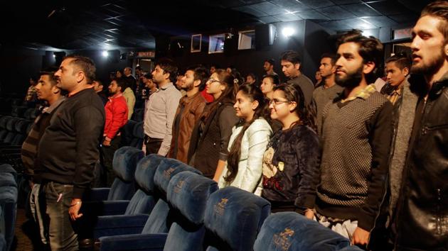 Indian movie goers stand up as national anthem is played at a movie hall before the screening of a movie in Jammu, India. The home ministry also asked states to ensure that all movie halls must play the national anthem and show the national flag on the screen when it is being played. (AP Photo) Indian movie goers stand up as national anthem is played at a movie hall before the screening of a movie in Jammu, India. The home ministry also asked states to ensure that all movie halls must play the national anthem and show the national flag on the screen when it is being played. (AP Photo)