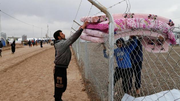 An Iraqi man who fled from Mosul, receives bedding at the Khazer camp in Iraq. (Ammar Awad / REUTERS)