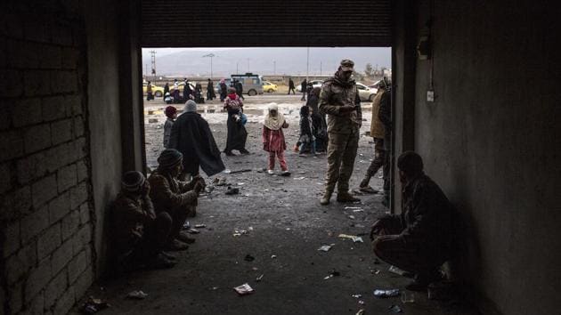 An Iraqi girl plays while waiting to be transferred to a camp with her family from a gathering point near Mosul. Hundreds of Iraqis were waiting to undergo a screening by the military before getting sent to displaced -people camps. (Manu Brabo / AP)