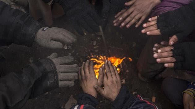 Displaced Iraqis warm themselves by a fire before being transferred to a camp near Mosul, Iraq. The onslaught of winter has created more hardships for the thousands of displaced. (Manu Brabo / AP)