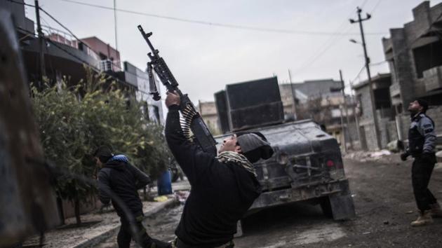 A member of the Iraqi Special Forces shoots his machine gun at a drone operated by Islamic State fighters in Mosul, Iraq. (Manu Brabo) / AP)