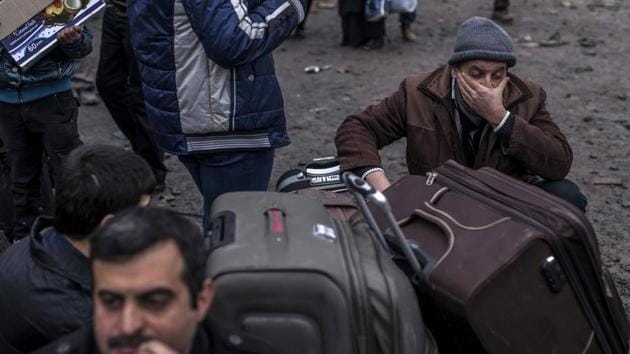 Iraqi civilians wait to be transferred to camps by the Iraqi Army near Mosul. The civilians, who had just arrived from Mosul, had their identity documents checked against a military database, before they are cleared. (Manu Brabo / AP)