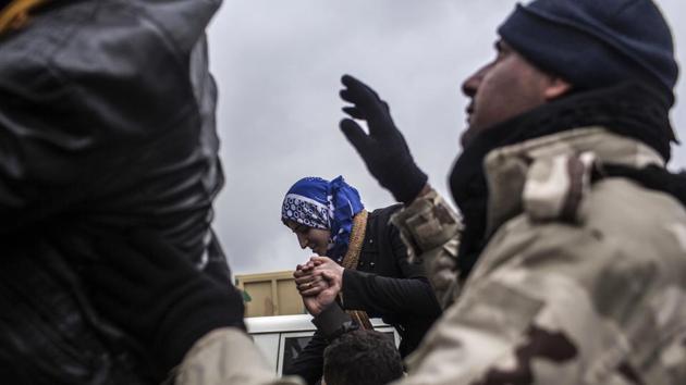 An Iraqi woman is helped into an army truck used to transfer civilians into nearby camps. Once they are given military clearance, civilians are loaded on to waiting trucks and sent to IDP camps east of the city. (Manu Brabo / AP)