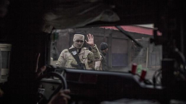 An Iraqi soldier waves to comrades in a humvee heading to the front line in the al-Barid district in Mosul, Iraq. (Manu Brabo/ AP)