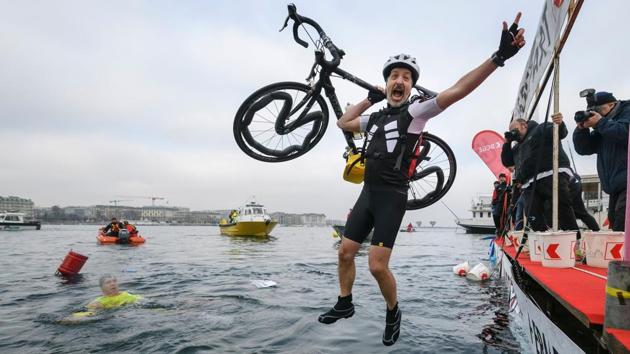 A swimmer jumps with his bicycle jumps into the water. (Fabrice Coffrini/AFP) A swimmer jumps with his bicycle jumps into the water. (Fabrice Coffrini/AFP)