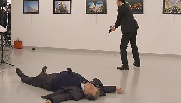 This picture taken on December 19 shows Andrey Karlov (L), the Russian ambassador to Ankara, lying on the floor after being shot by a gunman (R) during an attack during a public event in Ankara.(AFP)